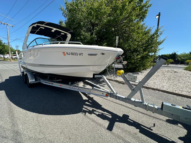 Slide: The Image of 2023 Chaparral 270 OSX boat on trailer, parked on a sunny street. - 5