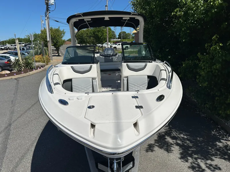 Slide: The Image of 2023 Chaparral 270 OSX boat, sleek design, parked outdoors on a sunny day. - 7