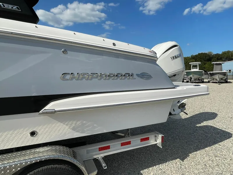 Slide: The Image of 2025 Chaparral 270 OSX boat on trailer, featuring Yamaha engine, under a clear blue sky. - 2
