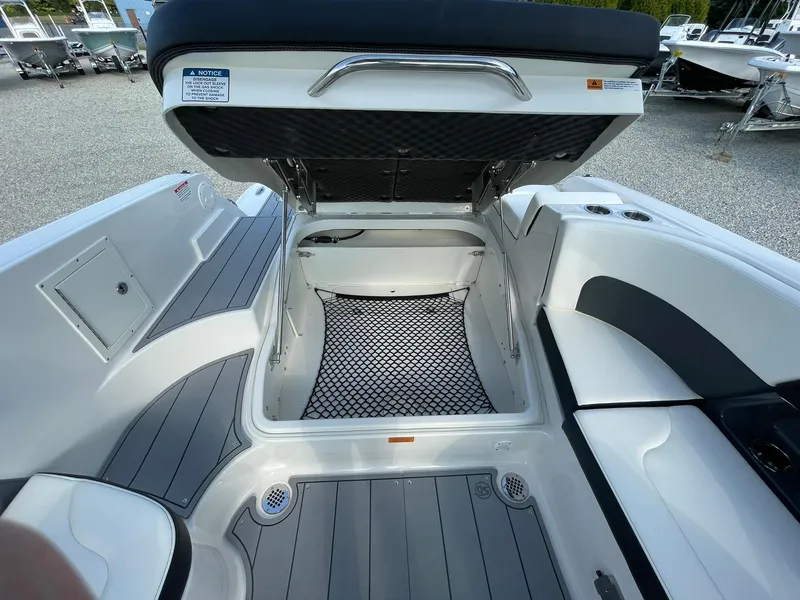 Slide: The Image of 2025 Chaparral 270 OSX boat interior with open storage compartment and seating area. - 40