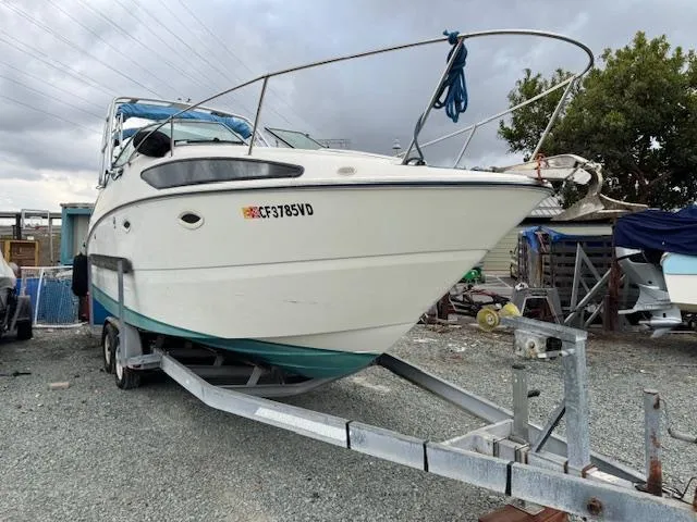 Slide: The Image of 2006 Bayliner 265 SD boat on trailer, parked outdoors under cloudy sky. - 15