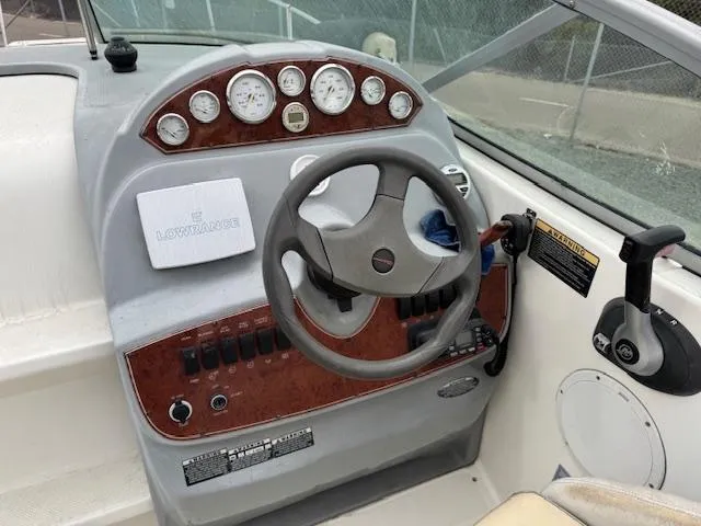 Slide: The Image of Dashboard of a 2006 Bayliner 265 SD boat with steering wheel and gauges. - 9