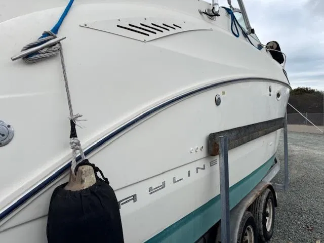 Slide: The Image of 2006 Bayliner 265 SD boat on trailer, side view with visible logo and fender. - 16
