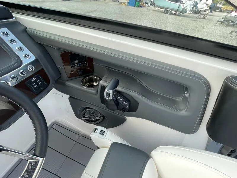 Slide: The Image of Interior view of 2025 Chaparral 270 OSX boat cockpit with controls and cup holder. - 26