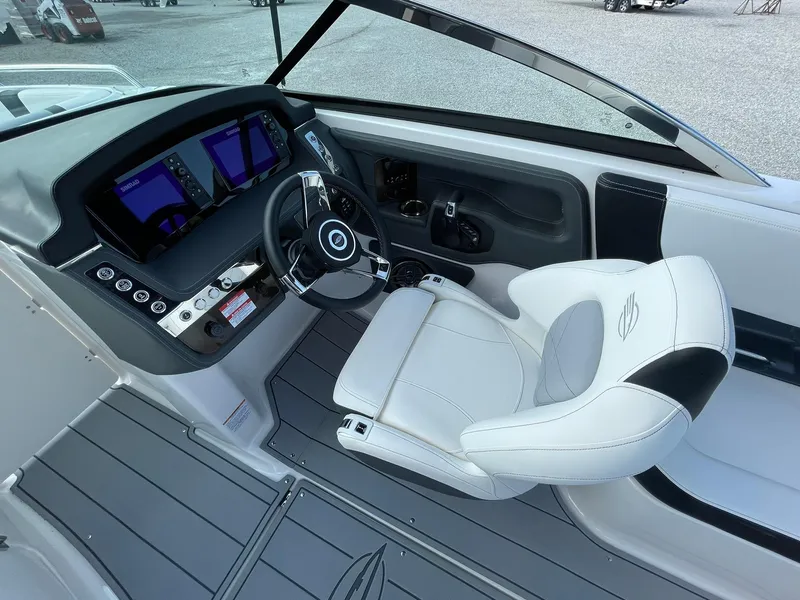 Slide: The Image of 2025 Chaparral 270 OSX boat cockpit with modern controls and white captain's chair. - 27