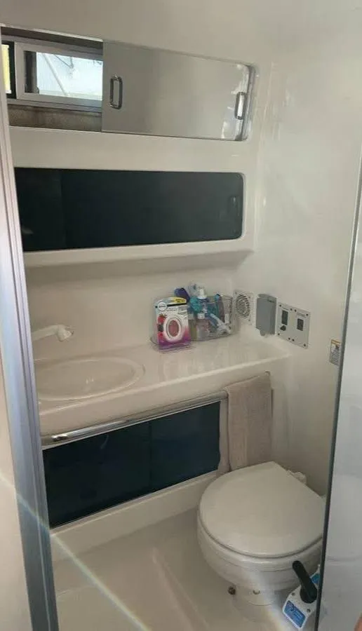Slide: The Image of 1998 Chaparral 270 Signature boat bathroom with toilet, sink, and storage cabinets. - 15