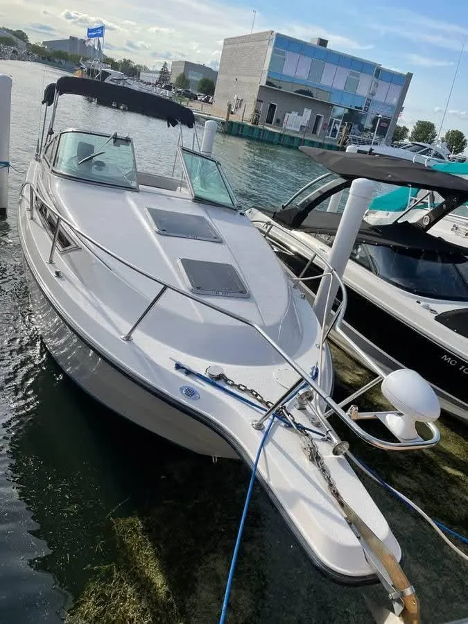 Slide: The Image of 1998 Chaparral 270 Signature boat docked at marina, featuring sleek design and spacious deck. - 2