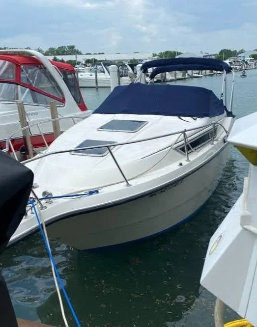 Slide: The Image of 1998 Chaparral 270 Signature boat docked in a marina with blue canopy. - 4
