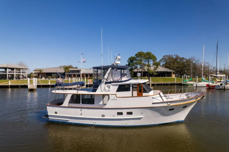Slide: The Image of 1992 DeFever 49 Pilothouse yacht on calm water, clear sky background. - 1