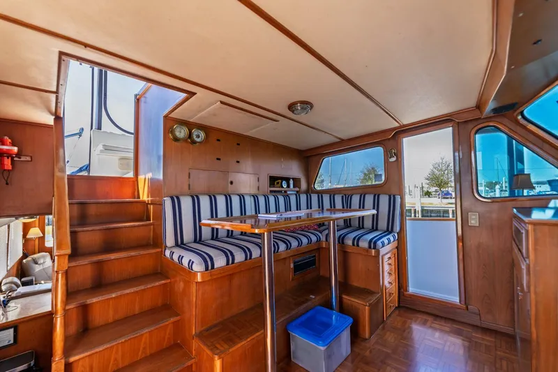 Slide: The Image of Interior of 1992 DeFever 49 Pilothouse with striped seating and wooden finishes. - 12