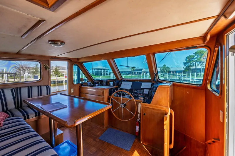 Slide: The Image of Pilothouse interior of 1992 DeFever 49, featuring helm, seating, and large windows. - 13