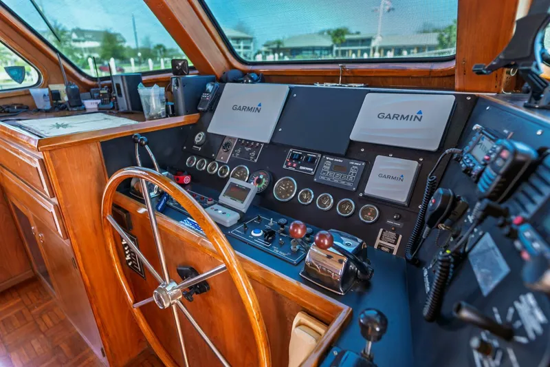 Slide: The Image of 1992 DeFever 49 Pilothouse helm with Garmin navigation, wooden wheel, and control panel. - 14