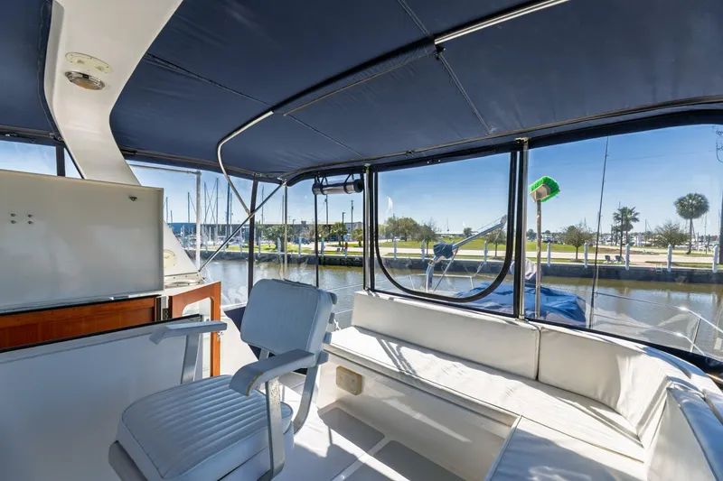 Slide: The Image of 1992 DeFever 49 Pilothouse interior with seating and marina view. - 20