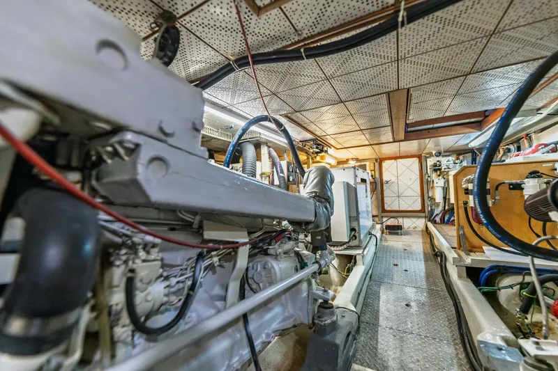 Slide: The Image of Engine room of 1992 DeFever 49 Pilothouse yacht, showcasing mechanical components and equipment. - 24