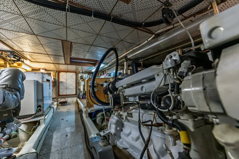 Slide: The Image of Engine room of 1992 DeFever 49 Pilothouse yacht, showcasing mechanical components and equipment. - 25