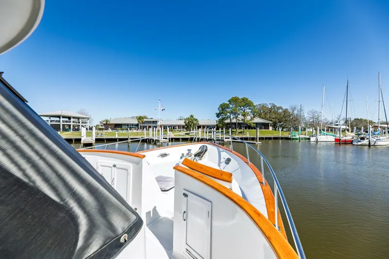 Slide: The Image of DeFever 49 Pilothouse yacht, 1992 model, docked in a serene marina under clear blue skies. - 29