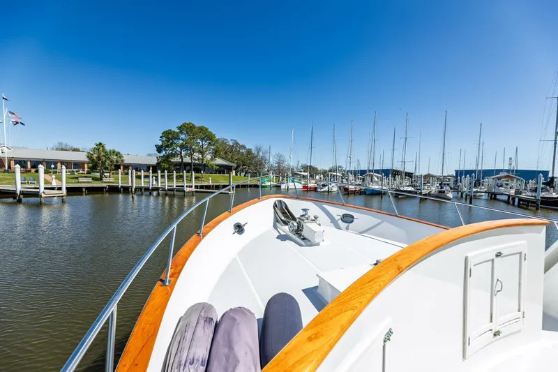 Slide: The Image of 1992 DeFever 49 Pilothouse yacht docked at a marina under clear blue skies. - 31