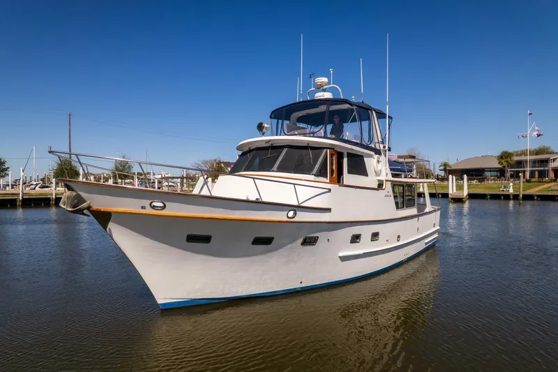 Slide: The Image of 1992 DeFever 49 Pilothouse yacht on calm water under clear blue sky. - 33