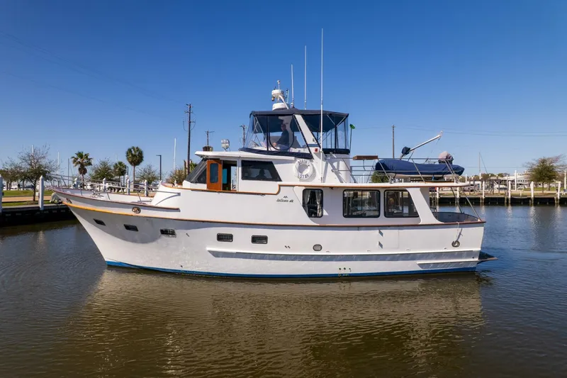 Slide: The Image of 1992 DeFever 49 Pilothouse yacht on calm water under clear blue sky. - 34