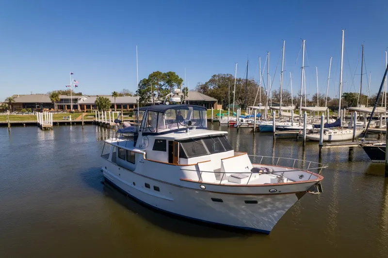 Slide: The Image of 1992 DeFever 49 Pilothouse yacht docked in a marina under clear blue skies. - 36