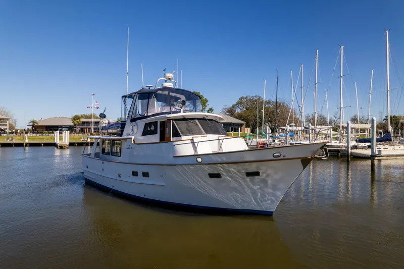 Slide: The Image of 1992 DeFever 49 Pilothouse yacht docked in a marina under clear blue skies. - 37
