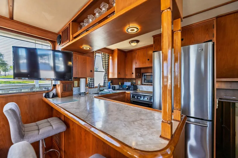 Slide: The Image of Luxurious 1992 DeFever 49 Pilothouse kitchen with modern appliances and elegant wood finishes. - 4