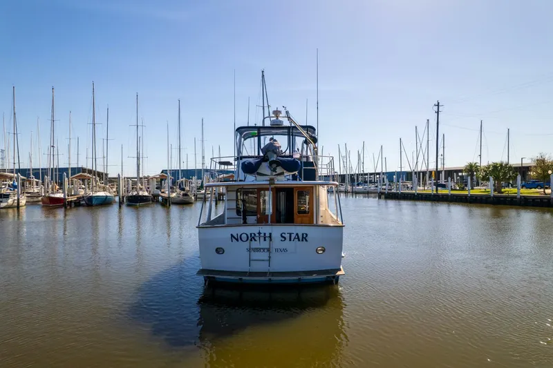 Slide: The Image of 1992 DeFever 49 Pilothouse yacht "North Star" docked in a marina under clear blue skies. - 40