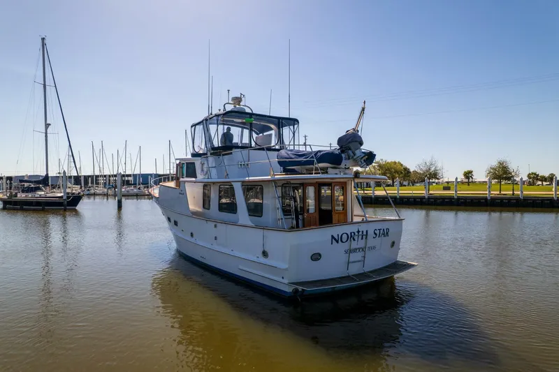 Slide: The Image of 1992 DeFever 49 Pilothouse yacht docked in a marina under clear skies. - 41
