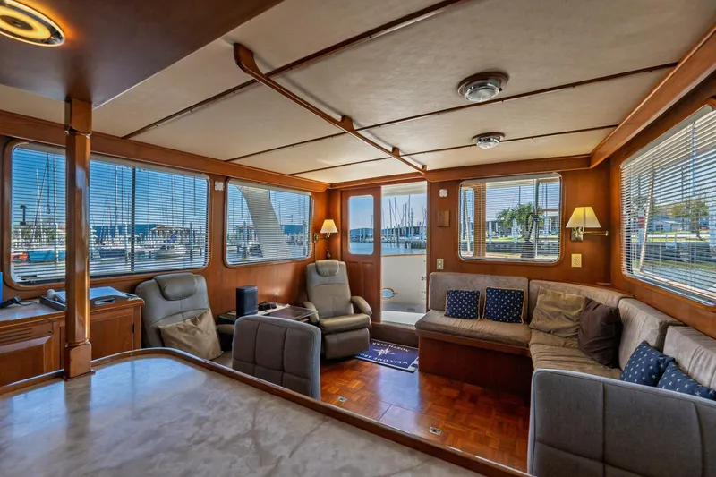 Slide: The Image of Luxurious interior of 1992 DeFever 49 Pilothouse yacht with comfortable seating and large windows. - 7