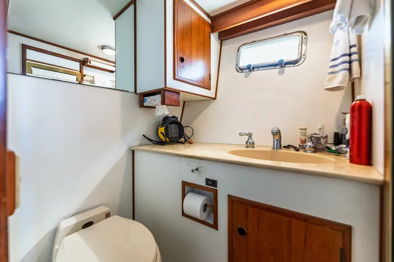 Slide: The Image of 1992 DeFever 49 Pilothouse bathroom with sink, toilet, and wooden cabinetry. - 9