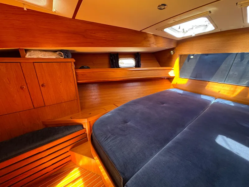 Slide: The Image of Cozy cabin interior of 2002 Jeanneau Sun Odyssey 45.2 with wooden finish and blue bedding. - 17