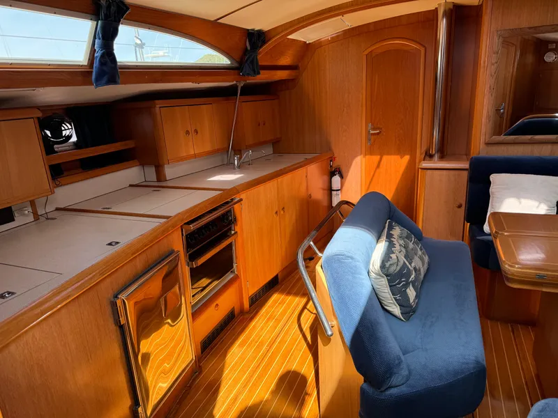 Slide: The Image of Interior of 2002 Jeanneau Sun Odyssey 45.2 yacht with wooden cabinetry and blue seating. - 24