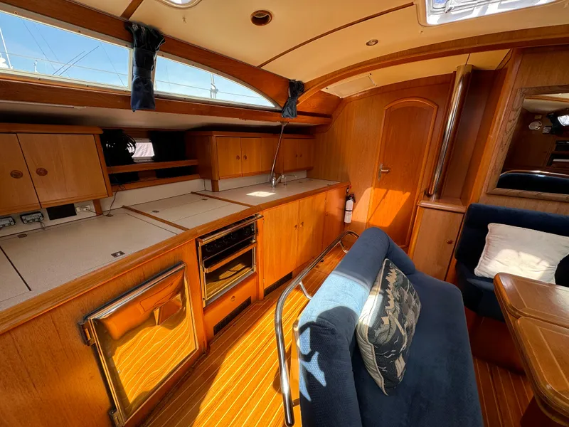 Slide: The Image of Interior of 2002 Jeanneau Sun Odyssey 45.2 sailboat with wood finish and cozy seating. - 26