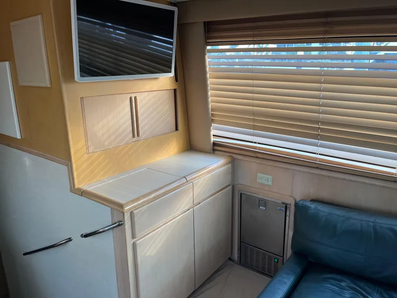 Slide: The Image of Interior of 1995 Hatteras 45 Convertible yacht with blinds, cabinets, and seating. - 15