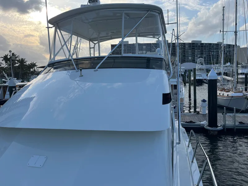 Slide: The Image of 1995 Hatteras 45 Convertible yacht docked at marina, under a cloudy sky. - 2