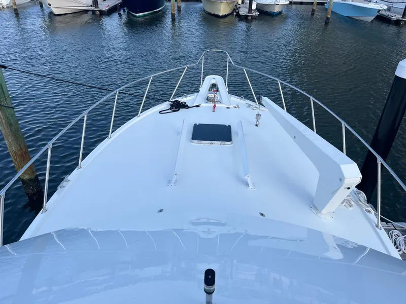 Slide: The Image of 1995 Hatteras 45 Convertible yacht docked in a marina, view from the bow. - 5