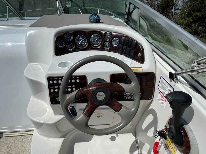 Slide: The Image of 2003 Crownline 262 CR boat dashboard with steering wheel and control panel. - 10