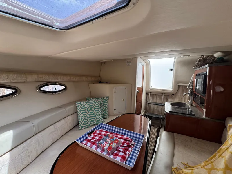Slide: The Image of Interior of 2003 Crownline 262 CR boat with seating, table, and kitchenette. - 16