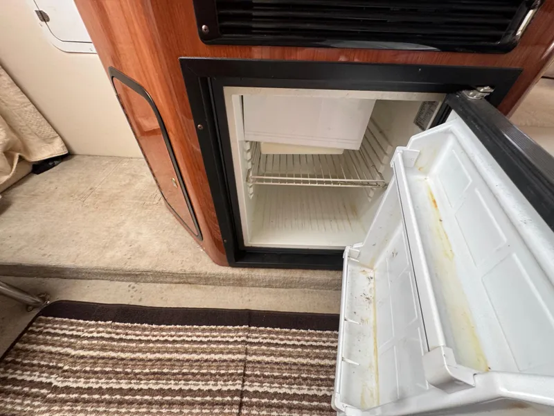 Slide: The Image of Open mini fridge inside 2003 Crownline 262 CR boat cabin. - 18