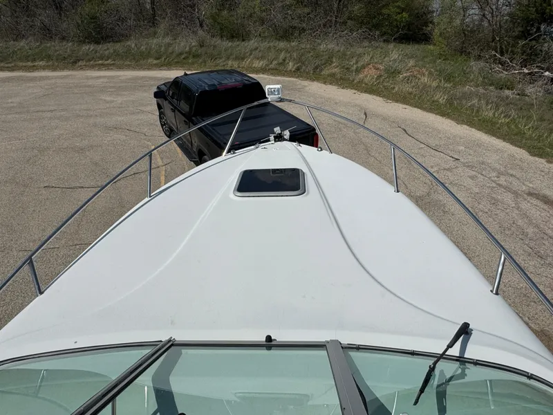 Slide: The Image of 2003 Crownline 262 CR boat on trailer, towed by a black truck in a parking area. - 6