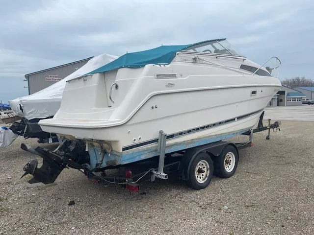 Slide: The Image of 1997 Bayliner 2355 SJ Ciera boat on trailer, parked outdoors under cloudy sky. - 3