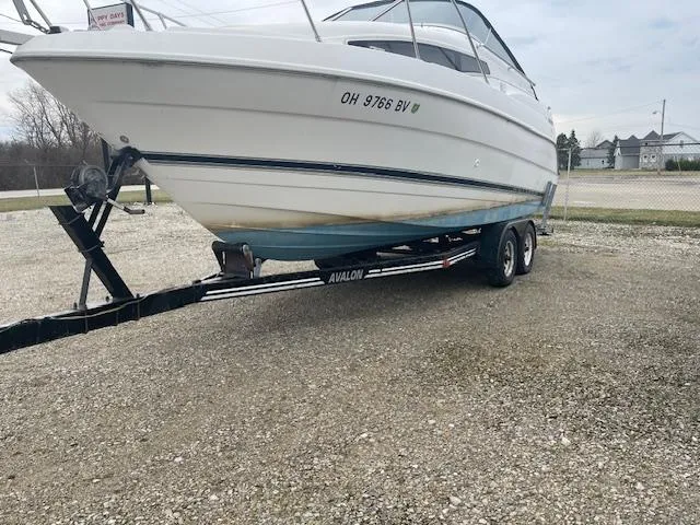 Slide: The Image of 1997 Bayliner 2355 SJ Ciera boat on trailer, parked on gravel lot. - 4