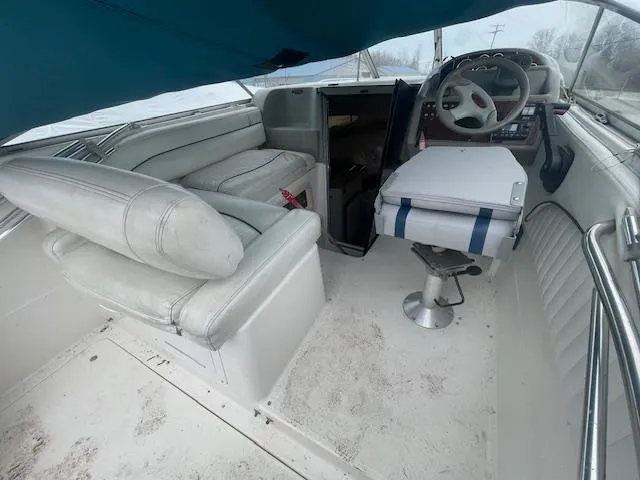 Slide: The Image of 1997 Bayliner 2355 SJ Ciera boat interior with white seating and steering area. - 6