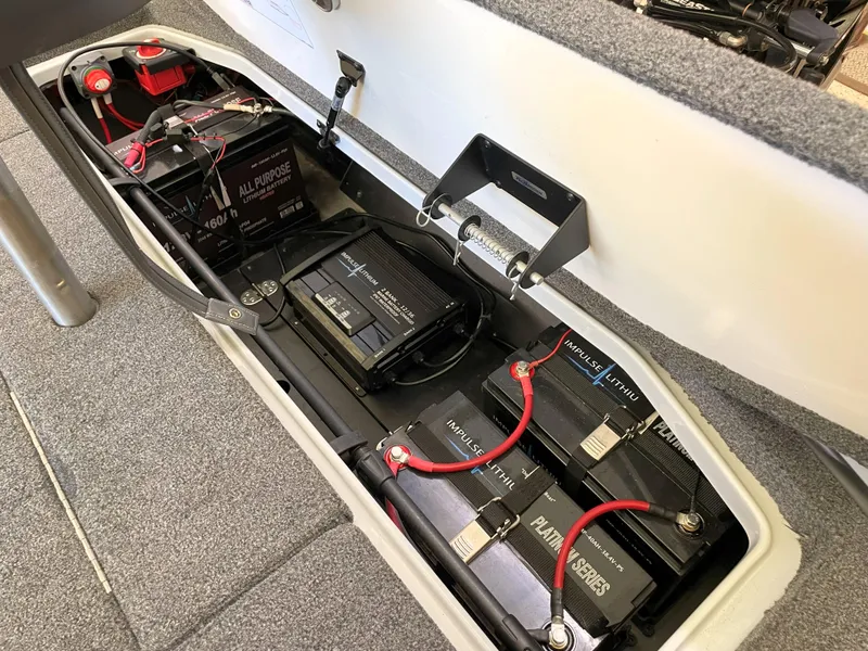 Slide: The Image of 2023 Ranger Z520R 55th Anniversary boat battery compartment with multiple batteries and wiring. - 49