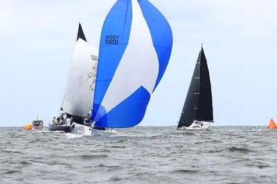Slide: The Image of Sailboats racing on open water, featuring a Columbia 32 from 2007. - 3