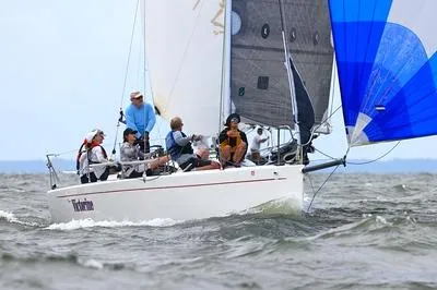 Slide: The Image of Sailboat Columbia 32, 2007 model, with crew navigating choppy waters. - 4