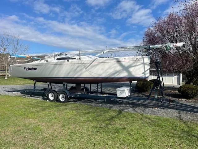 Slide: The Image of 2007 Columbia 32 sailboat on trailer, named Victorine, parked on grass under blue sky. - 5