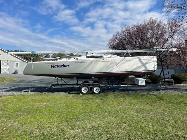 Slide: The Image of 2007 Columbia 32 sailboat on trailer, named "Victorine," parked on grass under a cloudy sky. - 6