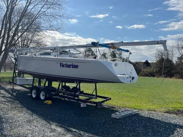 Slide: The Image of Sailboat "Victorine" on trailer, Columbia 32 model, 2007, parked on gravel near grassy field. - 9