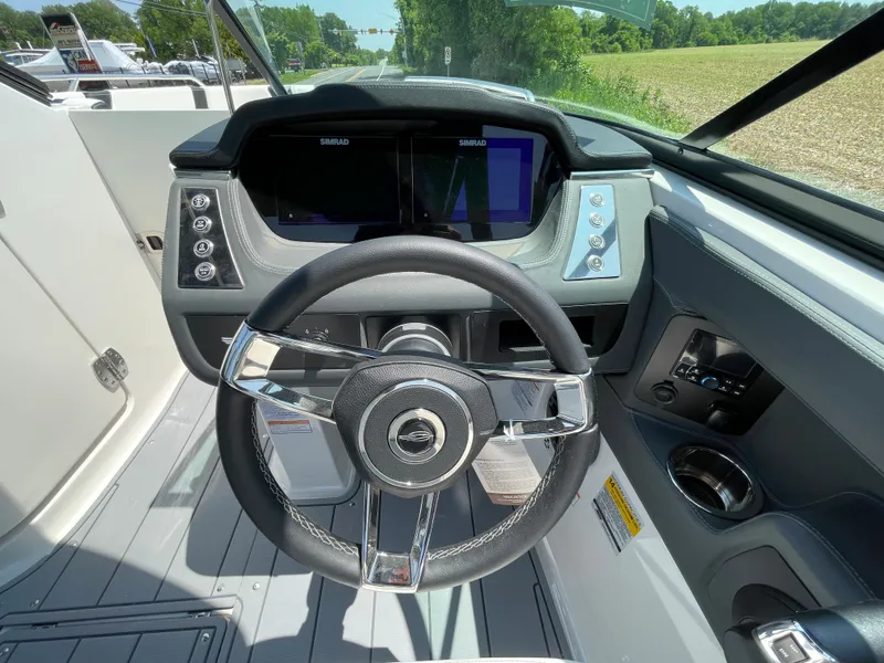 Slide: The Image of 2024 Chaparral 250 OSX boat dashboard with steering wheel and control panel. - 19